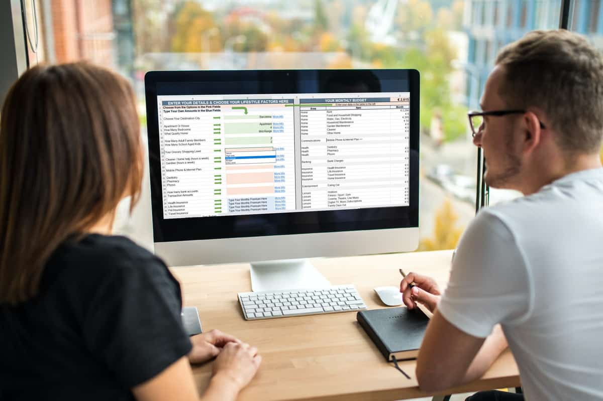 A couple looking at the cost of living calculator on a mac