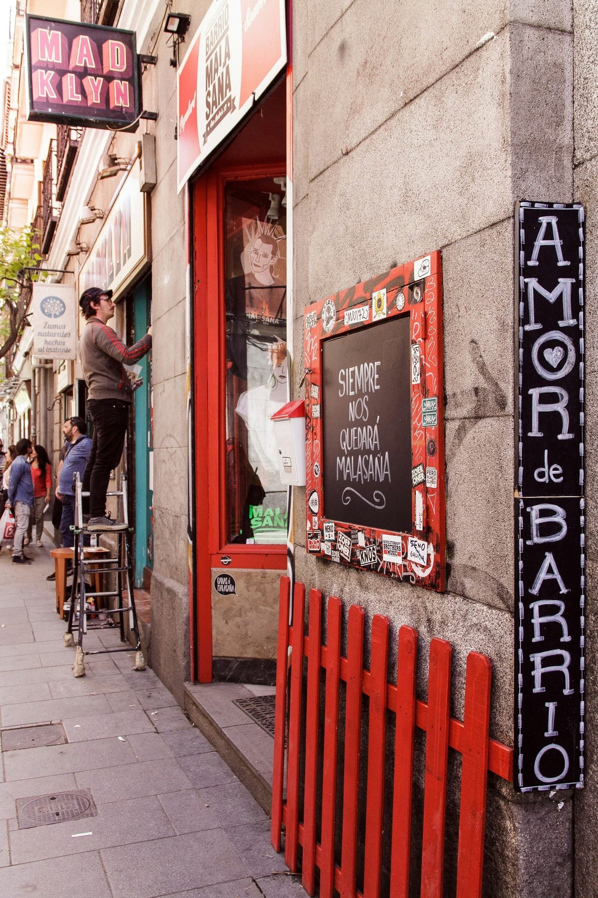 Independent shop fronts and hand-painted signs on a Malasaña street in central Madrid