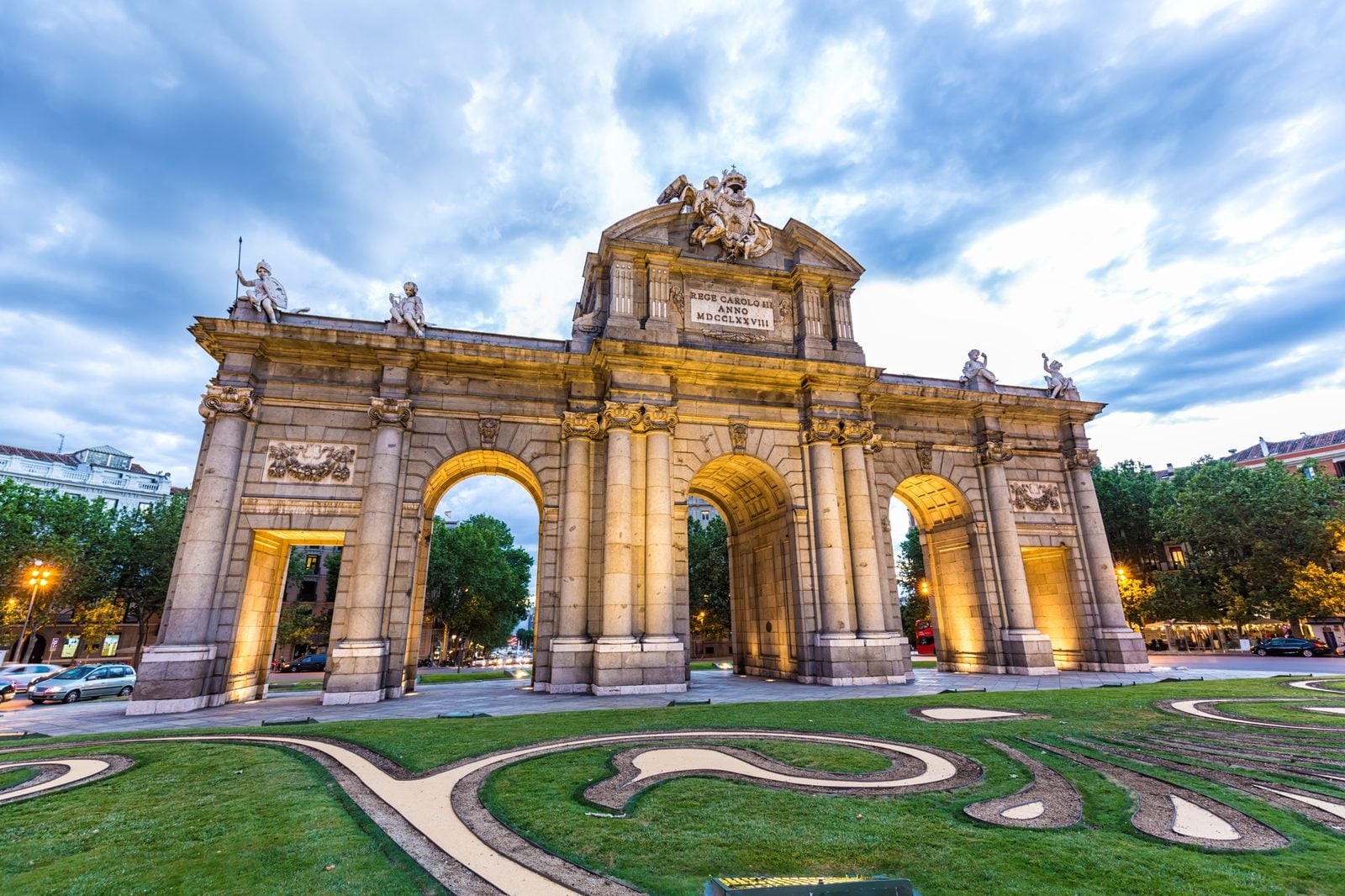 Puerta de Alcalá neoclassical arch illuminated at dusk at the edge of Madrid's Salamanca district
