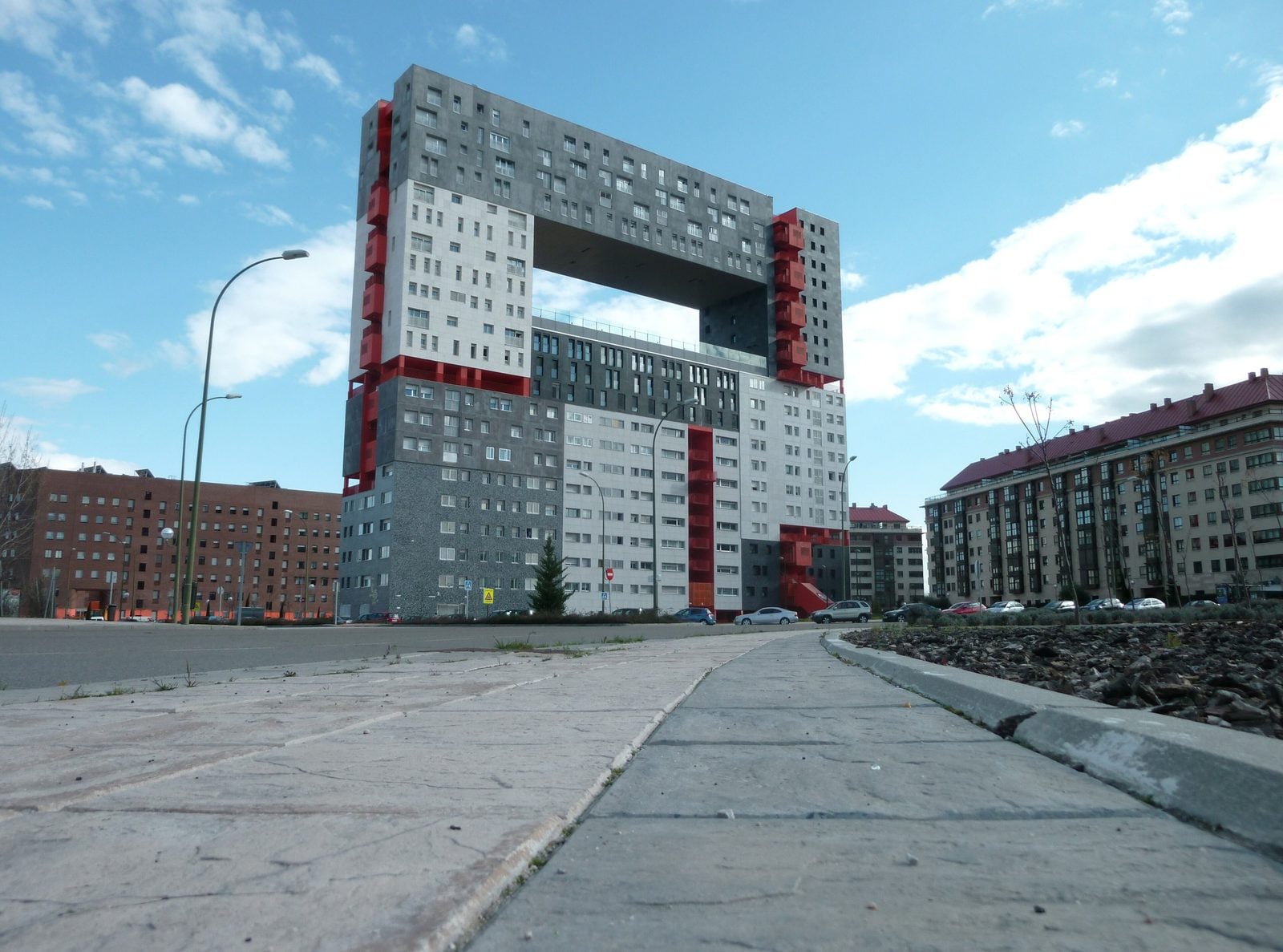 The red-and-grey Edificio Mirador residential building in Madrid's Sanchinarro neighborhood