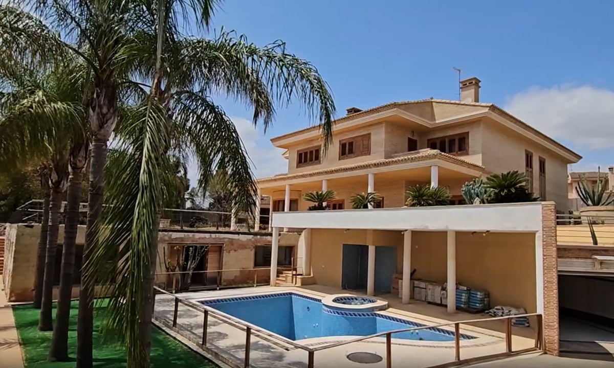 A triple story house in LÉliana that is typical of the area.  Spacious with a pool, law, and palm trees.