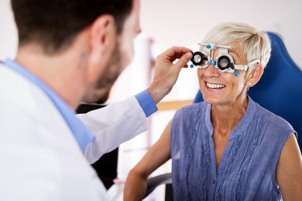 A lady over the age of 75 getting her eyes tested with a doctor