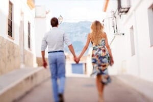 A married couple holding hadn walking down a Spanish road who are eligible for Spanish citizenship