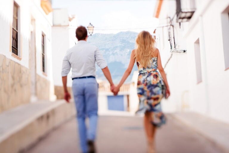 A married couple holding hadn walking down a Spanish road who are eligible for Spanish citizenship